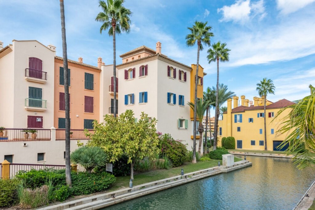 Marina apartments in Sotogrande with waterfront canals, palm trees and Mediterranean architecture